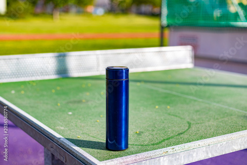 Blue vacuum insulated water bottle on outdoor table tennis table