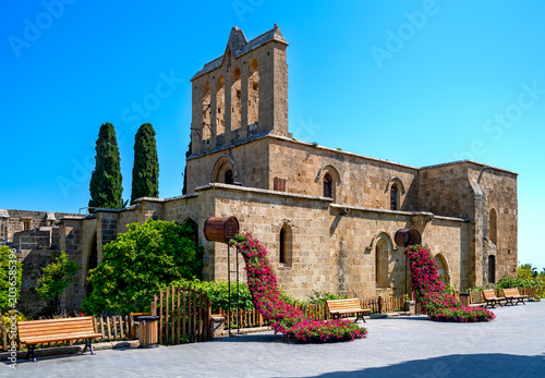 Bellapais Monastery with floral decorations against a blue sky at sunshine in the village of Kyrenia in Cyprus