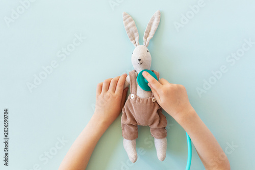 Fotografía Baby hands in roleplay as doctor, healing cute rabbit toy with stethoscope, developing compassion, creative imagination and care through playful medical game