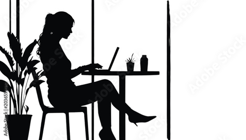 Silhouette of a woman sitting at a table with a laptop and plants, working in a bright, contemporary interior.