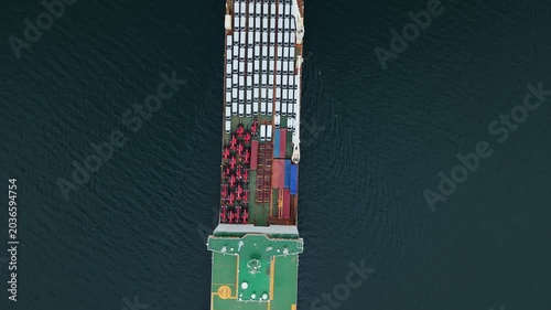 aerial view, A ship loaded with cars is anchored at the port in Halifax, Canada. The cargo ship prepares for export while containers are visible on deck. This is a busy area for car transport
