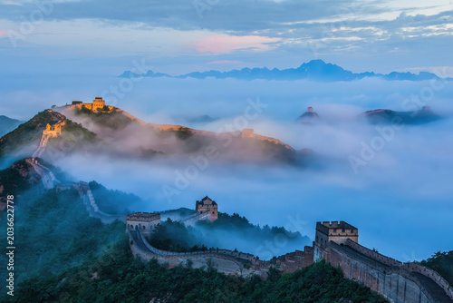Photos A stunning view of the Great Wall at Jinshanling during sunrise, with mist hovering over the landscape, creating a surreal and majestic atmosphere