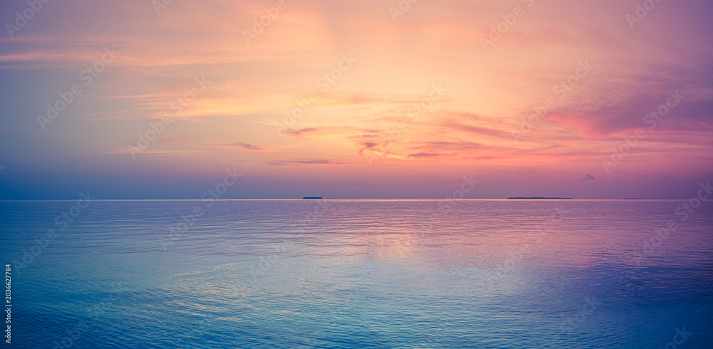 Obraz premium Tranquil panoramic pastel sunset calm ocean sea soft pink purple sky reflection horizon. Dreamy summer paradise escape, exotic vacation relaxation wellness mindfulness travel romantic seascape nature 