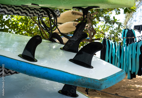 Close up of surfboards with black fins on a rack at a surf school in Sri Lanka.