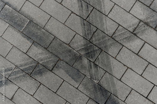 Photos Black tire skid marks on a grey paving slab background with copy space