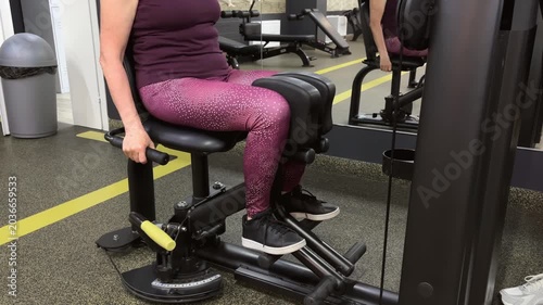 Older woman exercising on gym machine with focused expression indoors  