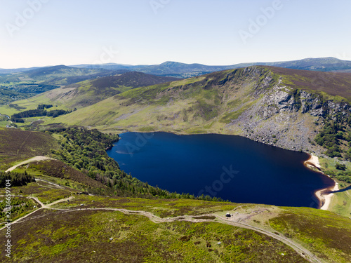 Stunning high angle shot of the iconic Guinness Lake showing the white sand beach and steep cliffs under a bright blue sky
