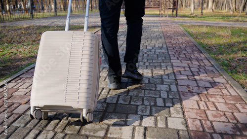 Close up of a person pulling a suitcase on a pavement