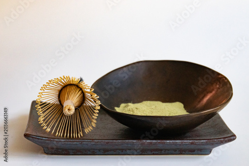 Traditional Matcha Whisk and Green Tea Powder in Ceramic Bowl