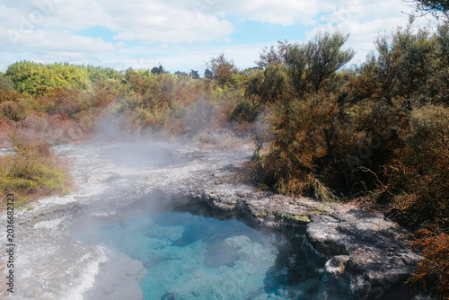 Rotorua, New Zealand: Vibrant blue geothermal hot spring pool with volcanic steam and white silica mineral crust margins at Te Puia thermal valley.