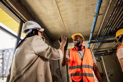 Canvastavla Diverse construction team celebrating with a high five during site meeting