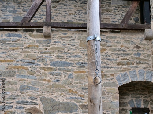 Cuadro en lienzo A close-up shot captures a historic iron pillory chain hanging from a vertical
weathered wooden pole