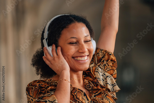 Photography portrait of a young latina woman with headphones listening to music happily