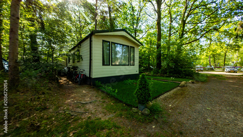 Cozy Dutch chalet-style summer house surrounded by forest. Peaceful woodland retreat, vacation accommodation, rustic architecture and nature getaway in the Netherlands.