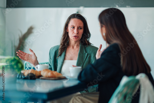 Konstfotografi Women arguing in a cafe during a business conflict, experiencing tension and fru