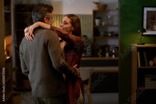 Obraz na plátně Couple embracing at home, expressing affection and relationship bonding