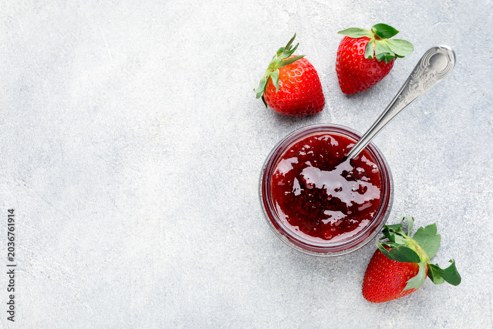 Fototapeta premium Tasty strawberry jam in jar and fresh berries on light grey table, flat lay. Space for text