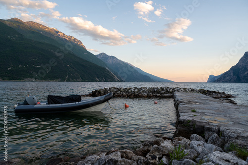 Small boat moored in a mountain lake bay at sunset.