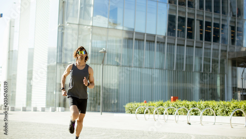 Fotografie Runner moves swiftly in cityscape during bright daylight hours