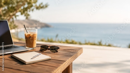 Coastal remote work desk with laptop iced coffee sunglasses and notebook