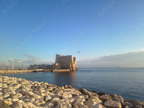 Seafront in Naples, Italy. Ovo Castle under blue sky