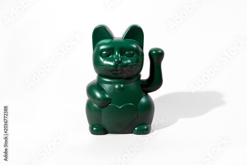 A green Maneki-neko lucky cat figurine with an upright waving paw isolated on a clean white background