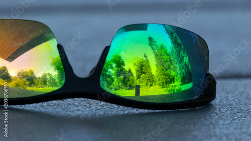 Park trees and picnic shelter reflected in abandoned sunglasses