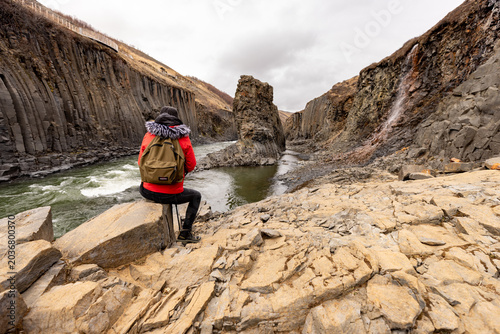 Foto Randonneur observant un canyon volcanique sauvage sous un ciel dramatique