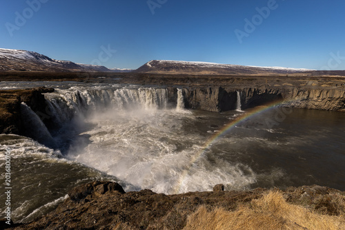 Obraz na plátně Cascade puissante dans un paysage naturel sauvage avec embruns et ciel dégagé
