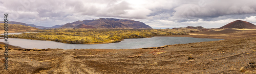 Vue panoramique d’une vallée islandaise avec rivière et terrain volcanique
