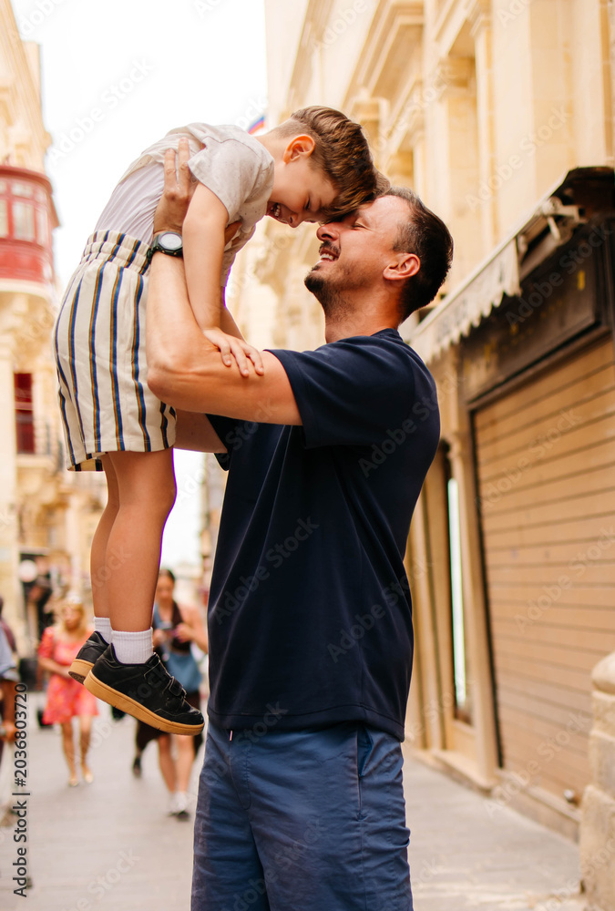 Obraz premium A father plays with his son on vacation in the old town.