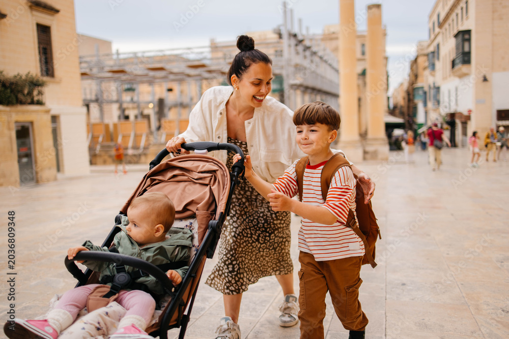Naklejka premium Mother and two twin kids travelers