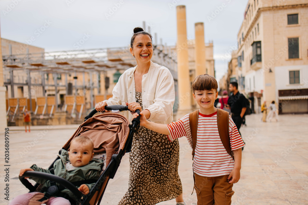 Naklejka premium Mother and two twin kids travelers