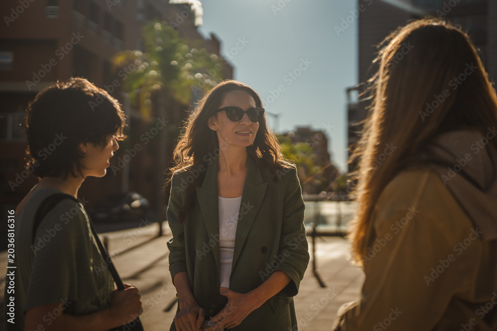 Fototapeta premium Women friends having urban conversation on city street