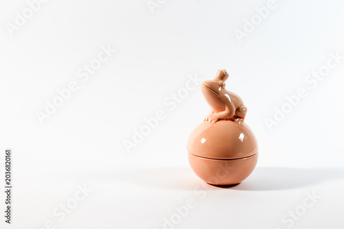 Pink decorative bowl with frog wearing a crown isolated on a clean white background