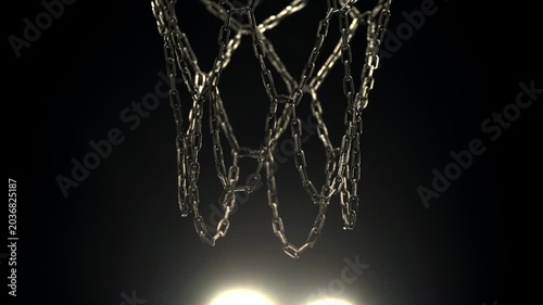 Basketball entering the hoop on an outdoor court at night with visible street light in the background. Urban sports atmosphere with dramatic lighting and cinematic night game feeling.
