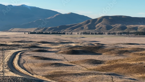 The road through a barren and arid stunning landscape to the mountains around Lake Oahu with snow on the peaks reflected on the village side of the Lake. One of my favourite lakes in NZ 