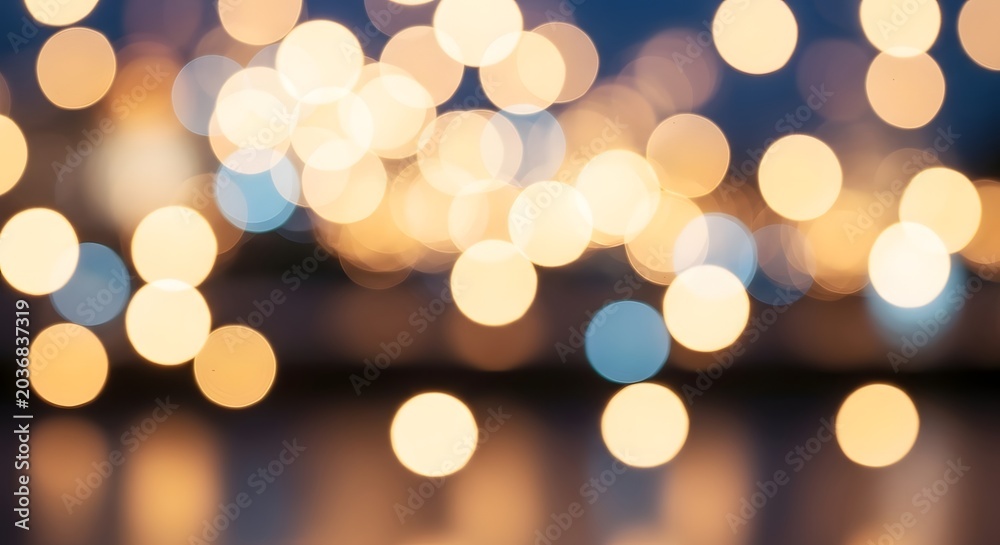 Fototapeta premium Abstract bokeh lights background with warm golden and cool blue tones creating a festive and dreamy atmosphere.