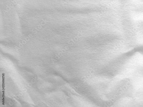 A high-resolution close-up of a white crumpled tissue paper surface. This neutral background features soft shadows and a fine fibrous texture, perfect for minimal design and clean overlays.