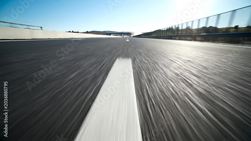 Fast motion blur on asphalt road during daytime with clear sky.
