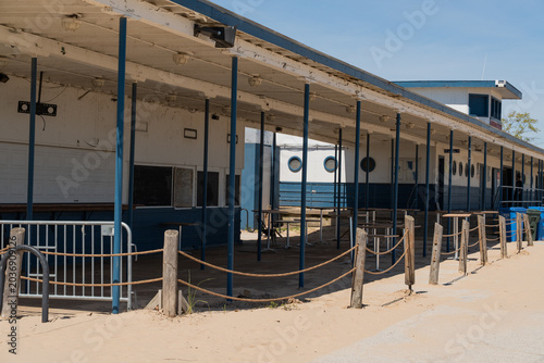 Vászonkép Outdoor dining area on the beach with empty tables and chairs under covered roof