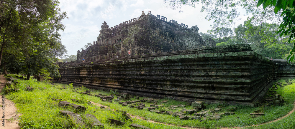 Naklejka premium Tourists explore the ancient Baphuon temple, a 11th-century Khmer architectural marvel, at Angkor Archaeological Park in Siem Reap, Cambodia.