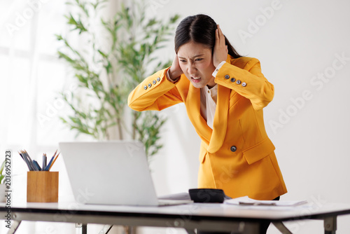 Canvas Print Asian businesswoman covering ears with hands, feeling loud noise, having a heada