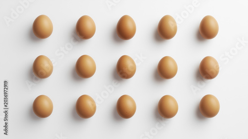 Brown eggs neatly arranged on a white surface, showcasing simplicity and natural food.