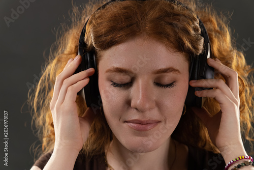 Young woman closing eyes, listening to music, finding peace and mindfulness