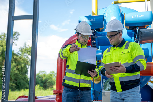 Konstfotografi Expert engineers and chief foremen are collaborating on plans for the expansion of the large-scale oil production plant