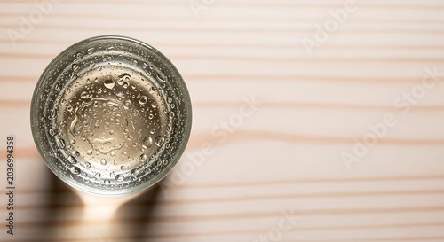 Empty glass on wooden table surface.