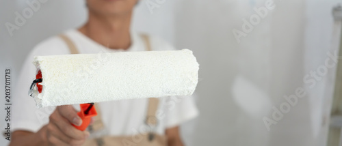 Foto painter man, brush in hand for products to restore and paint the wall, indoor th