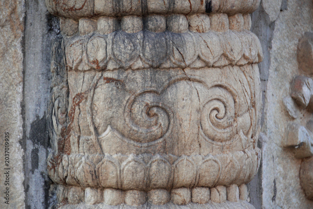 Obraz premium Intricate stone carving with spiral patterns on an ancient column