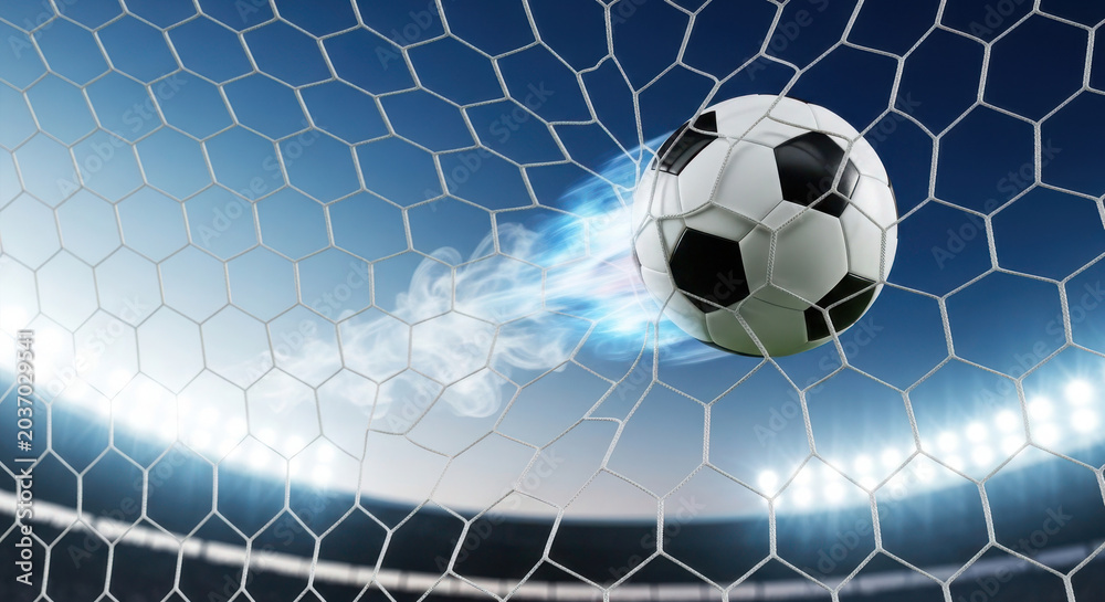 Fototapeta premium A high-speed soccer ball with a glowing fire trail crashes into the back of a stadium goal net, creating a dramatic and powerful visual representation of a championship winning goal during match play.